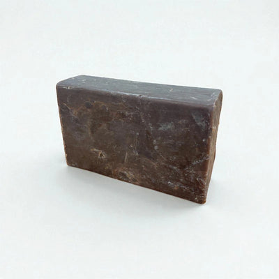 Pain rectangulaire brun de savon à la nigelle et au chocolat sur fond blanc