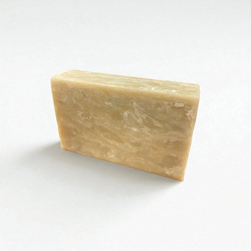 Pain rectangulaire beige de savon à la nigelle, lavande et argile verte