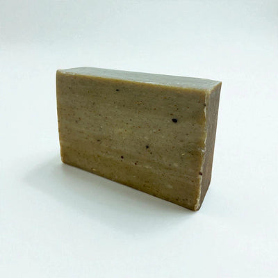 Pain rectangulaire vert olive de savon à la nigelle et au moringa sur fond blanc