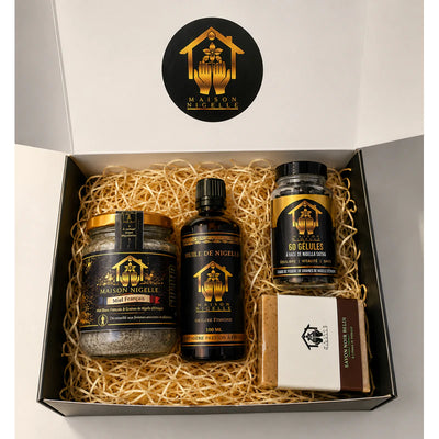 Box ouverte contenant quatre produits à la nigelle sur une garniture en papier